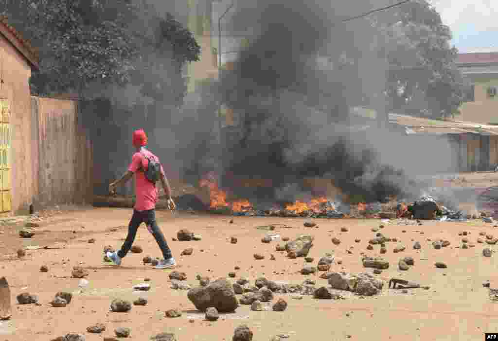 Protesters burn barricades and tires in Conakry street during a demonstration in Guinea. At least one teenager was killed, according to a doctor, in clashes between security forces and thousands of opponents to a third term of President Alpha Conde.