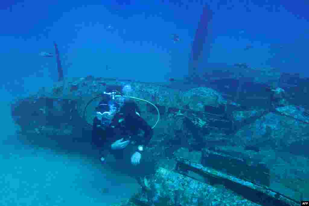 A diver explores the wreckage of an American bombardier fighter plane from the Second World War, the Lockheed P-38G Lightning, at 38 meters of depth, off the coast of La Ciotat, southern France.