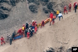 In this photo provided by the government news agency Andina, rescue workers surround an injured man on a stretcher who was lifted up from the site of a bus crash at the bottom of a cliff, in Pasamayo, Peru, Jan. 8, 2018.