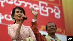 Burma's pro-democracy leader Aung San Suu Kyi (L) gives her speech beside the National League for Democracy party's candidate for the Seikkan Township constituency, Dr. Myo Aung at Seikkan, Rangoon, March 21, 2012