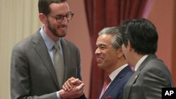 State Sen. Scott Wiener, D-San Francisco, left, receives congratulations from Assemblyman Rob Bonta, D-Alameda, center, and Sen. Kevin de Leon, D-Los Angeles, right, after his net neutrality bill was approved by the state Senate, Aug. 31, 2018, in Sacramento, Calif. 