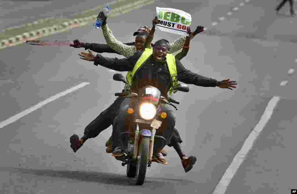 کینیا، نیروبی میں مظاہرین ایک موٹر سائکل پر سوار ہاتھ میں پلے کارڈ آٹھائے جا رہے ہیں
