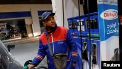 FILE - A gas station attendant pumps fuel into a customer's car at a gas station in Tunis, Tunisia, March 31, 2018.