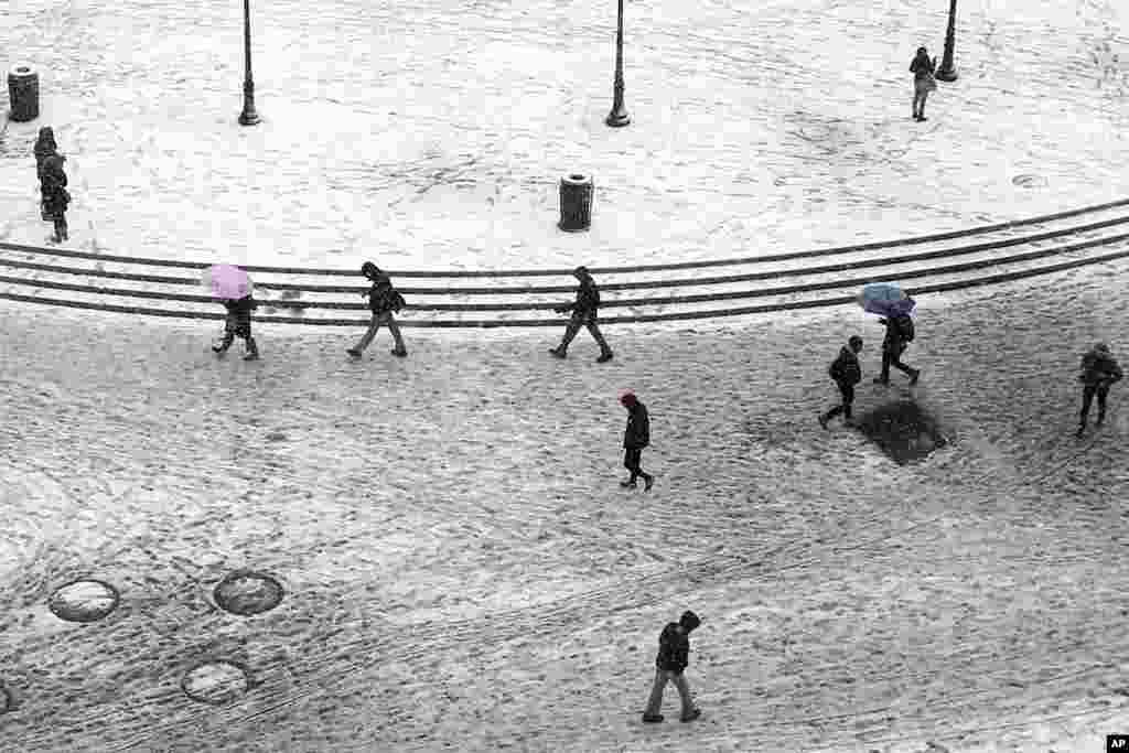 Pedestrians trudge through dirty snow and slush as they pass through Union Square in New York. Another winter storm bears down on the eastern U.S., only a day after temperatures soared into the 50s.