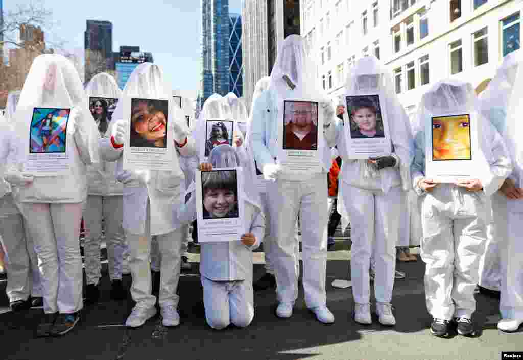Protesters hold photos of school shooting victims during a &quot;March For Our Lives&quot; demonstration in New York City, 2018.