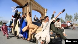 FILE - People celebrate the cease-fire in Rodat district of Nangarhar province, Afghanistan, June 16, 2018.