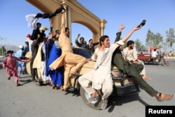 People celebrate the cease-fire in Rodat district of Nangarhar province, Afghanistan, June 16, 2018.