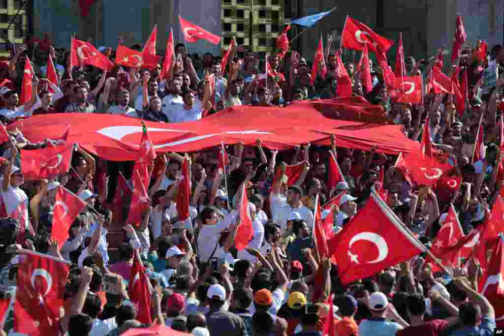 Turkish citizens wave their national flags as they protest against the military coup outside Turkey's parliament near the Turkish military headquarters in Ankara, Turkey, July 16, 2016. 