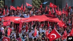 FILE - Turkish citizens wave their national flags as they protest against the military coup outside Turkey's parliament near the Turkish military headquarters in Ankara, Turkey, July 16, 2016. 