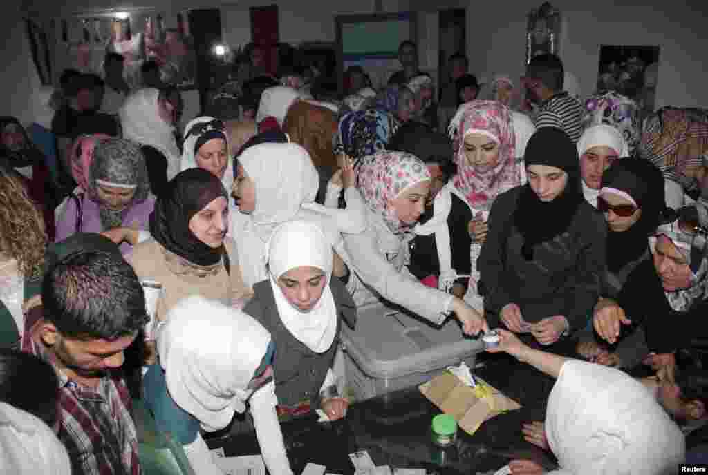 Women cast their votes in presidential elections at a polling station in Aleppo, Syira, June 3, 2014. 