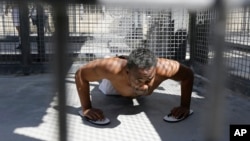 Condemned inmate Donald DeBose does pushups in a caged recreation yard space of the adjustment center on death row at San Quentin State Prison in San Quentin, Calif., Aug. 16, 2016. A pair of November ballot measures will decide the future of the death penalty in California.