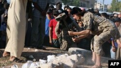 An image made available by propaganda Islamist media outlet Welayat Halab on July 2, 2015, allegedly shows an IS fighter destroying artifacts smuggled from the Syrian city of Palmyra in the town of Manbij, northeast of Aleppo.