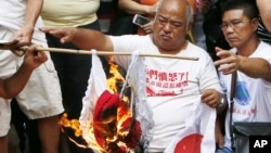 Anti-Japan protesters burn Japanese flags outside the Japanese Consulate General in Hong Kong, September 16, 2012. 