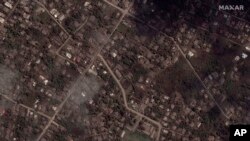 This satellite image provided by Maxar Technologies shows ash covered homes and buildings in Tonga, Jan. 18, 2022 after a huge undersea volcanic eruption.