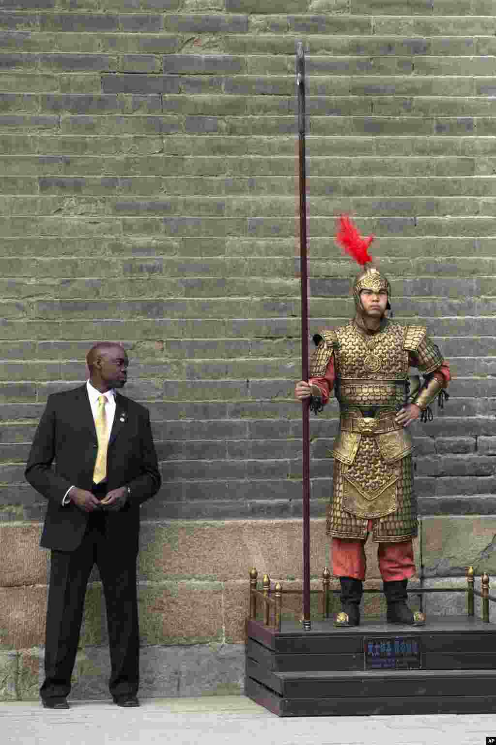 A U.S. secret service officer checks a Chinese performer dressed as an ancient warrior as U.S. first lady Michelle Obama visits a nearby city wall in Xi&#39;an, in northwestern China&#39;s Shaanxi province.