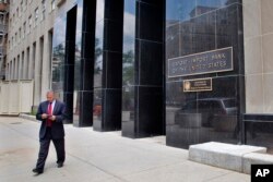 FILE - a man walks out of the Export-Import Bank of the U.S. in Washington. With little fanfare, Congress has revived the federal Export-Import Bank five months after allowing it to expire.