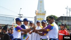 Walikota Yogyakarta Haryadi Suyuti (ke-3 dari kanan) bersama panitia Pelaksana Asian Games ke-18 menerima Obor di monumen Tugu Yogyakarta, titik terakhir sebelum dibawa ke Surakarta, Kamis (19/7).(Foto: VOA/Munarsih Sahana)