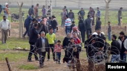 Syrians cross the border from Ras al-Ain to the Turkish border town of Ceylanpinar after an air strike by Syrian government forces, December 3, 2012.