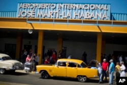 FILE - People put their luggage in a private taxi as they arrive from the U.S. to the Jose Marti International Airport in Havana, Cuba, Sept. 1, 2014.
