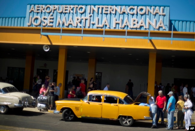 ຜູ້ຄົນ ທີ່ເດີນທາງໄປເຖິງ ສະໜາມບິນສາກົນ Jose Marti ໃນນະຄອນຮາວານາ ພວມເອົາເຄື່ອງຂຶ້ນລົດແທັກຊີ