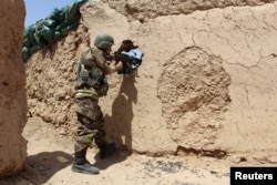 FILE - An Afghan National Army (ANA) soldier mans his position at an outpost in Babaji area of Lashkar Gah Helmand province, Afghanistan.