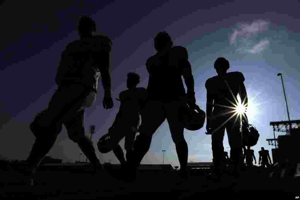 Houston Texans football players walks across a practice field before the start of a joint NFL training camp football practice with the Detroit Lions in Houston.