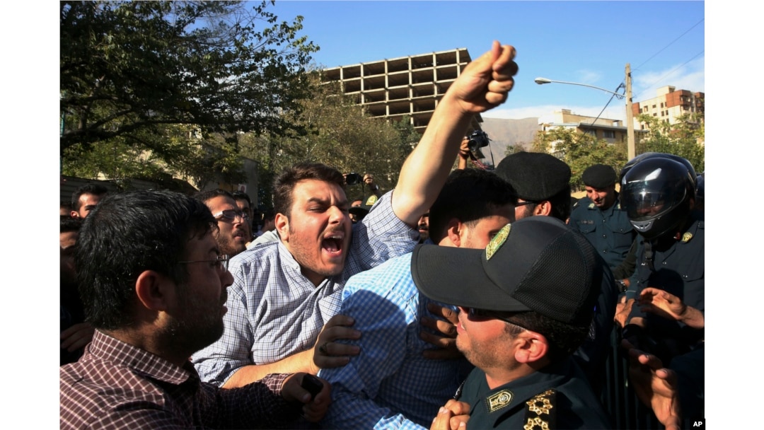 An Iranian protester chants slogans while police officers prevent him from approaching to the Saudi Arabian Embassy in Tehran, Iran, Sept. 27, 2015, during a gathering to blame the Arab country for a deadly stampede.