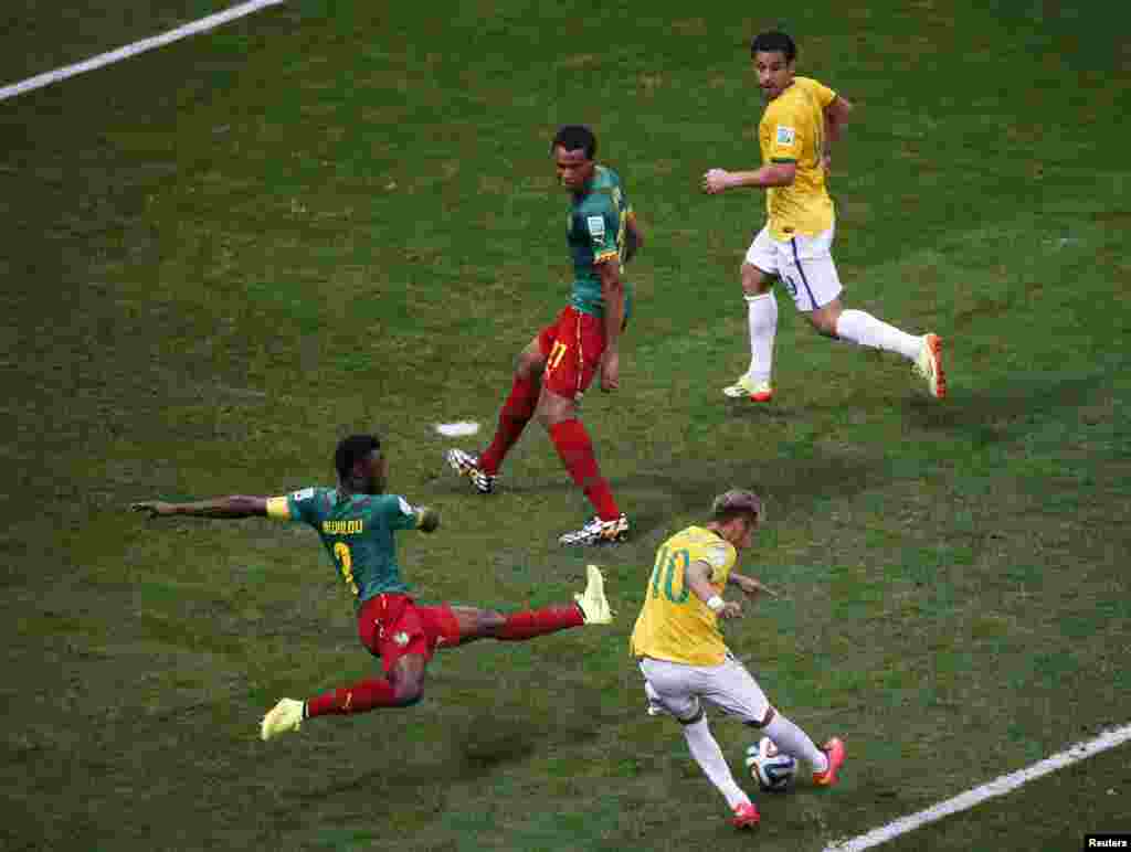 Brazil&#39;s Neymar scores past Cameroon&#39;s Nicolas Nkoulou during their match at the Brasilia National Stadium in Brasilia, June 23, 2014.