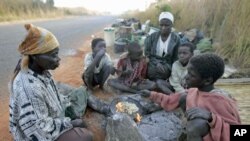 Family members of evicted farm workers cook breakfast on the side of the road outside Mvurwi village, about 130 kilometers west of Harare, May 2008. (file photo)