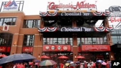 FILE - Fans gather outside the new Ballpark Village entertainment complex across the street from Busch Stadium before a St. Louis Cardinals baseball game, April 7, 2014. The village is one of the major downtown projects designed to help rebuild the city's image.