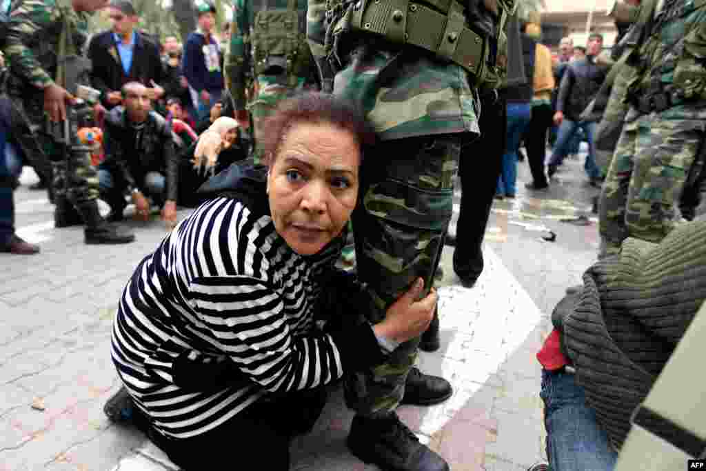 January 20: A Tunisian protester grabs hold of a soldier's leg for safety as shots are fired in the air in front of the headquarters of the Constitutional Democratic Rally (RCD) party of ousted president Zine al-Abidine Ben Ali in downtown Tunis. (Reuters