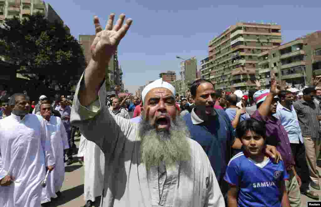 Para pendukung Ikhwanul Muslimin dan presiden terguling Mohamed Morsi meneriakkan slogan menentang militer dan Menteri Dalam Negeri Mesir sambil memberikan simbol &quot;Rabaa&quot; di Kairo, 23 Agustus 2013.