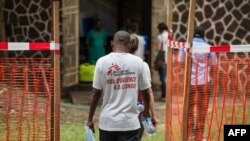 Des membres de l'équipe de Médecins Sans Frontières (MSF) traversent une zone de sécurité Ebola à l'entrée de l'hôpital de référence Wangata à Mbandaka, au nord-ouest de la RDC, le 20 mai 2018.