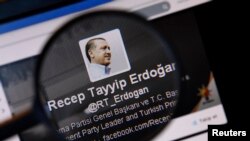 FILE - An image of Turkish Prime Minister Tayyip Erdogan on a Twitter account is pictured through a magnifying glass in this illustration picture taken in Istanbul March 21, 2014.