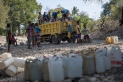 Warga memasukkan jerigen ke truk usai mengambil air dari sumber air di Desa Sanleo, Kabupaten Malaka, Nusa Tenggara Timur, 10 Oktober 2015. (Foto: Prasetyo Utomo/Antara via Reuters)