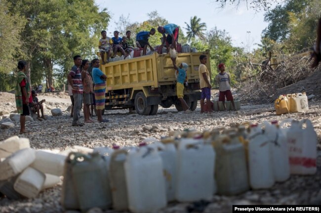 Warga memasukkan jerigen ke truk usai mengambil air dari sumber air di Desa Sanleo, Kabupaten Malaka, Nusa Tenggara Timur, 10 Oktober 2015. (Foto: Prasetyo Utomo/Antara via Reuters)
