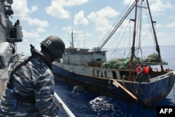 KRI Imam Bonjol-363 (kiri) menahan kapal nelayan China di perairan Natuna, 21 Juni 2016. (Foto: TNI AL via AFP)