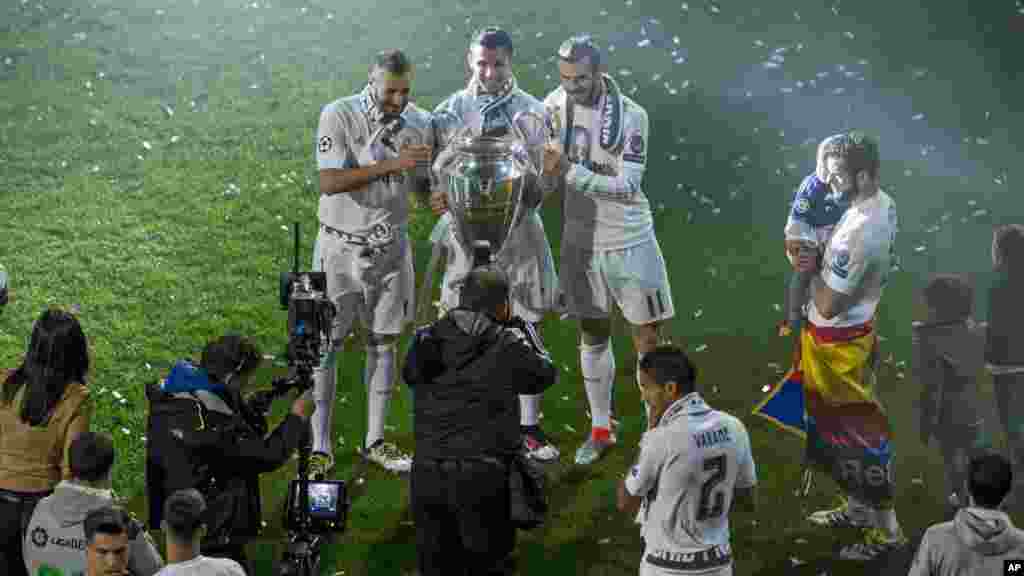 Les joueurs du Real Madrid Karim Benzema, Cristiano Ronaldo et Gareth Bale posent pour une photo avec le trophée qu'ils ont remporté, le 29 mai 2016.