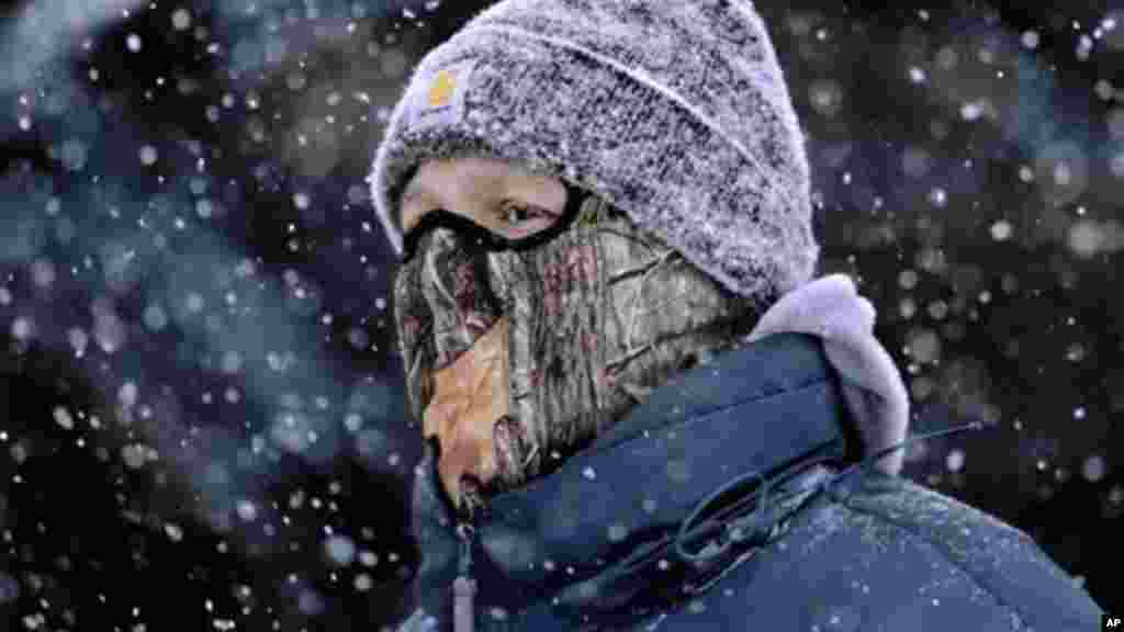 A man wears a face mask and heavy clothes while walking through downtown Springfield, Illinois, Jan. 5, 2014. 