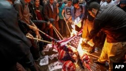Warga Iran membakar bendera AS dalam aksi demonstrasi di Teheran pasca keputusan AS keluar dari perjanjian nuklir Iran, hari Rabu (9/5). 