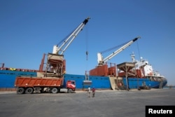 FILE - Workers unload aid shipments of wheat from St. George ship, at the Red Sea port of Hodeidah, Yemen, Nov. 30, 2017.