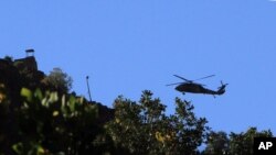 FILE - A Turkish military helicopter flies toward Iraq near Cukurca, Hakkari, Turkey, at the border with Iraq, Oct. 20, 2011.