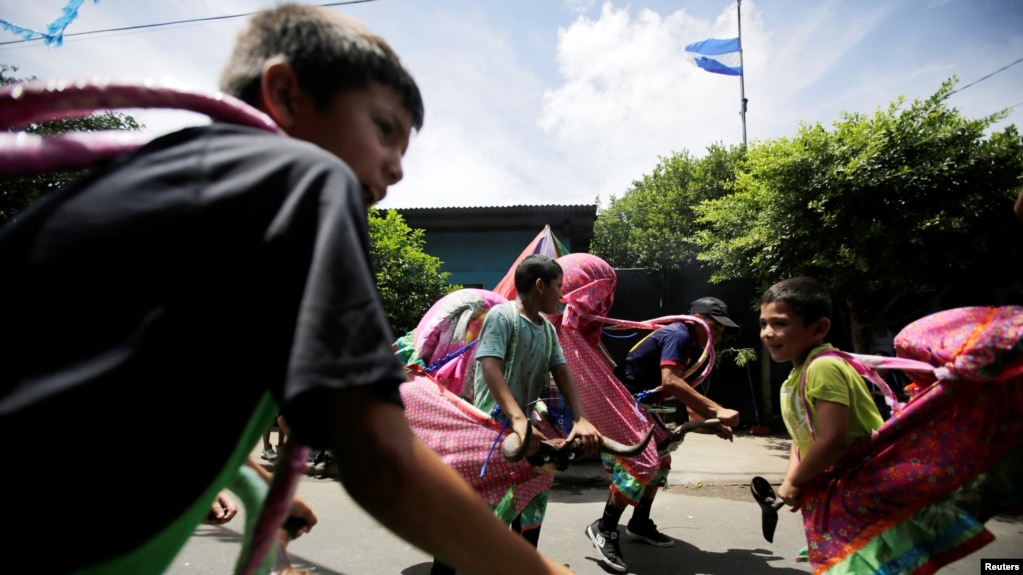 NiÃ±os nicaraguenses disfrazados juegan en la calle antes de las festividades en honor del santo patrÃ³n de la naciÃ³n Santo Domingo de GuzmÃ¡n. Managua, 1 de agosto de 2018.