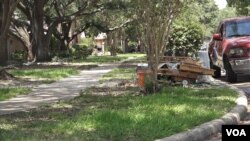 Debris from the hurricane clean up sits by the curb in the Bear Creek neighborhood. (E. Lee/VOA)