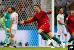 Pemain Portugal Cristiano Ronaldo merayakan gol ketiganya dengan tendangan bebas saat bermain imbang di grup B, 3-3, dengan Spanyol di Piala Dunia 2018 di Stadion Fisht di Sochi, Rusia, 15 Juni 2018. (Foto: AP)