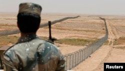 FILE - A member of the Saudi border guards force watches Saudi Arabia's northern borderline July 14, 2014. 