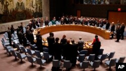 Delegates stand during a moment of silence in honor of victims of terrorism at a meeting of the United Nations Security Council regarding the threat of foreign terrorist fighters during the 69th session of the U.N. General Assembly at U.N. headquarters, Wednesday, Sept. 24, 2014.