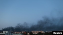 Black smoke billows in the sky above areas where clashes are taking place between pro-government forces, who are backed by the locals, and the Shura Council of Libyan Revolutionaries, in Benghazi, April 18, 2015. 
