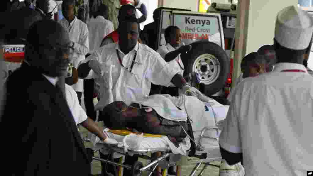 Médicos e pessoal médico no Hospital Nacional Kenyatta ajudam um homem ferido no ataque dos rebeldes extremistas islâmicos da Somália. O ataque na Terça-feira no norte do pais, perto de al-Shabab, deixou pelo menos 14 pessoas mortos e 11 feridos, diz um oficial de Quénia, 7 de Julho, 2015.