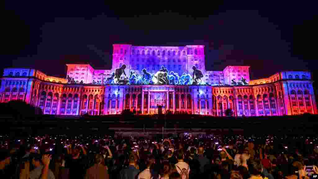 People watch projections during iMApp 2021, a video mapping event attended by artists from the United States, Germany, Ukraine, Japan and Hungary, in Bucharest, Romania, Sept. 18, 2021.